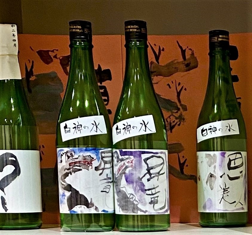 竜が描かれたラベルの貼られた透明な緑の瓶に入った「昇竜」、「思美人」の地酒の商品が並んでいる写真