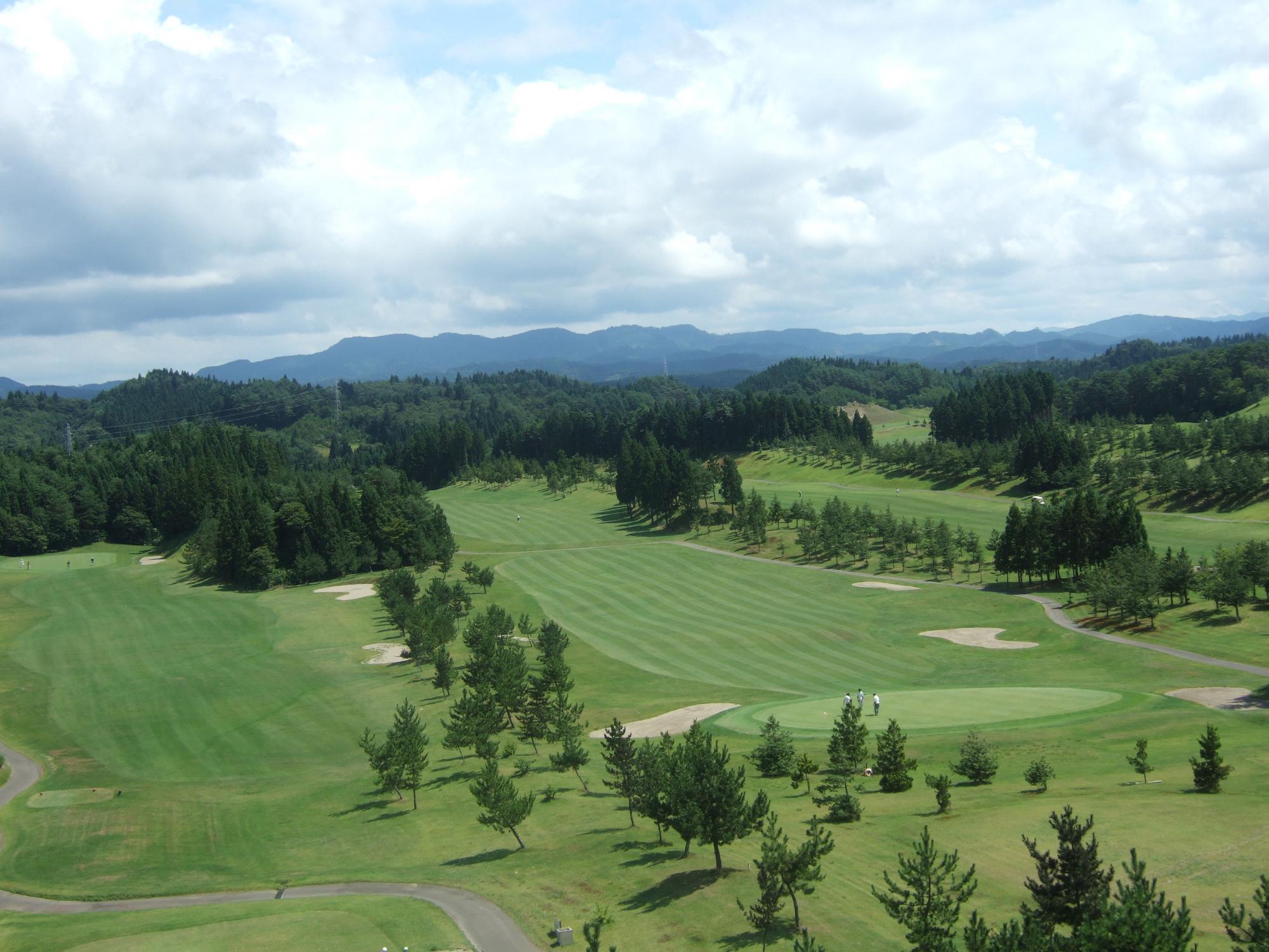 緑の木々と雄大な芝生のコースが広がっている秋田森岳温泉36ゴルフ場全体の写真